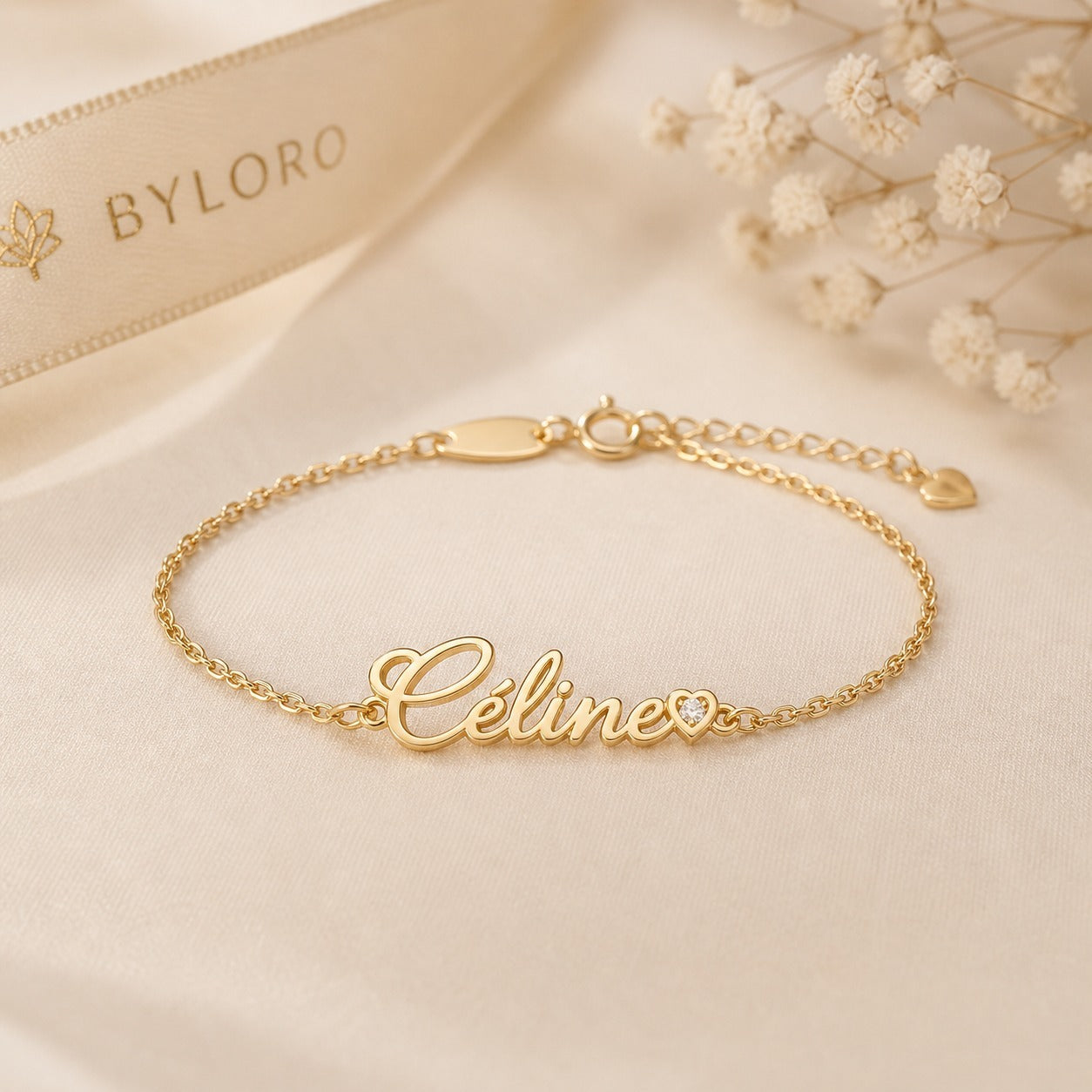 Echte detailfoto van de gouden Lovi Baby bracelet met sluiting en naam